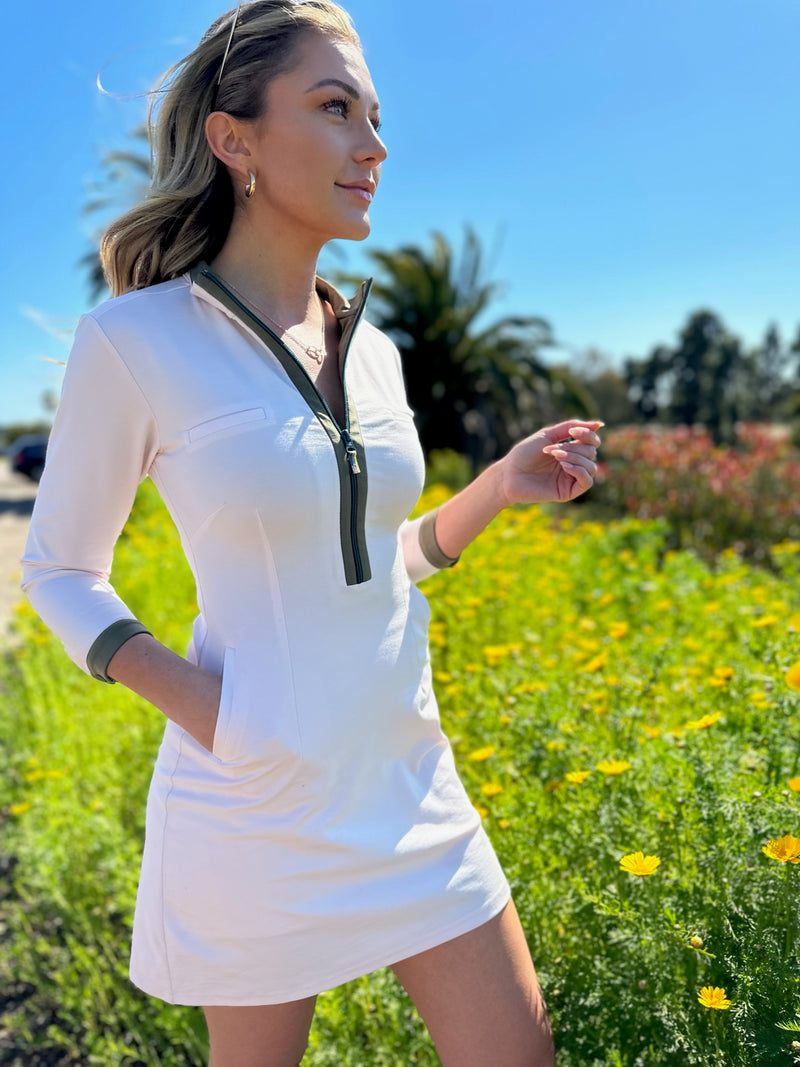 Load image into Gallery viewer, Model wearing white Dutchess womens golf dress with long sleeves with teal zipper.
