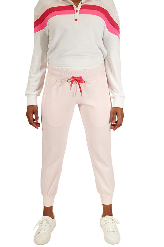 Model wearing pink women's golf joggers and white murray golf shirt in a studio shot..
